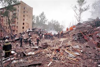 Firefighters and emergency workers search the ruins of a Moscow apartment building destroyed by a bombing, September 1999 
